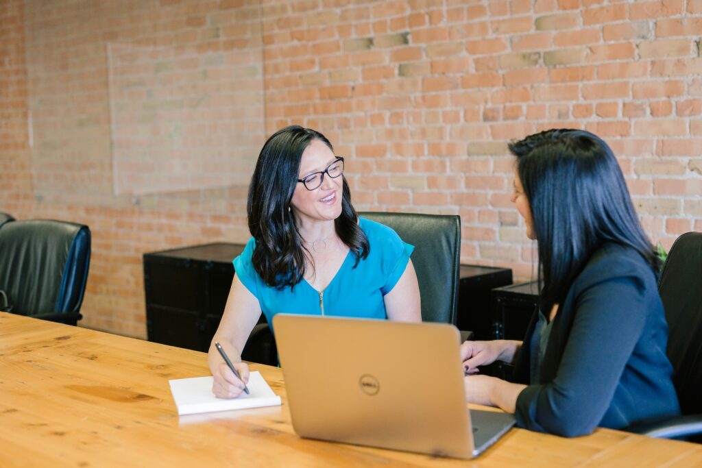 two women sitting at a table talking